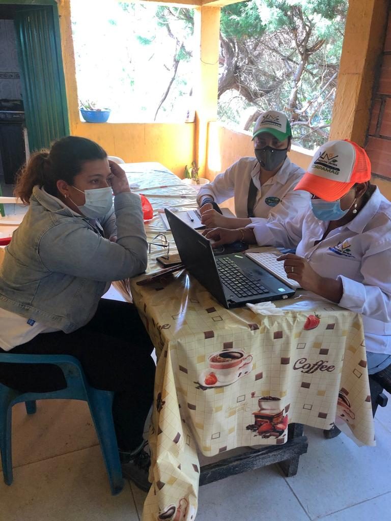 En la primera imagen se observa a dos funcionarias de Negocios Verdes en una mesa con un computador, realizando verificación de cumplimiento de criterios a representante de la finca La Colina.
En la segunda imagen se observa a una funcionaria de Negocios Verdes realizando entrevista al representante legal de la Asociación Red Ecolsierra en su oficina.