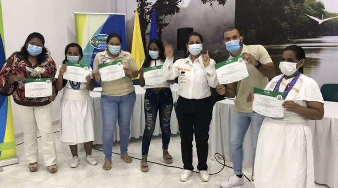 Negocios Verdes Asociación Mujeres Frutos de mi Tierra, Wirakoku, y Asoprosierra recibiendo certificado de capacitación en el auditorio de Corpamag.