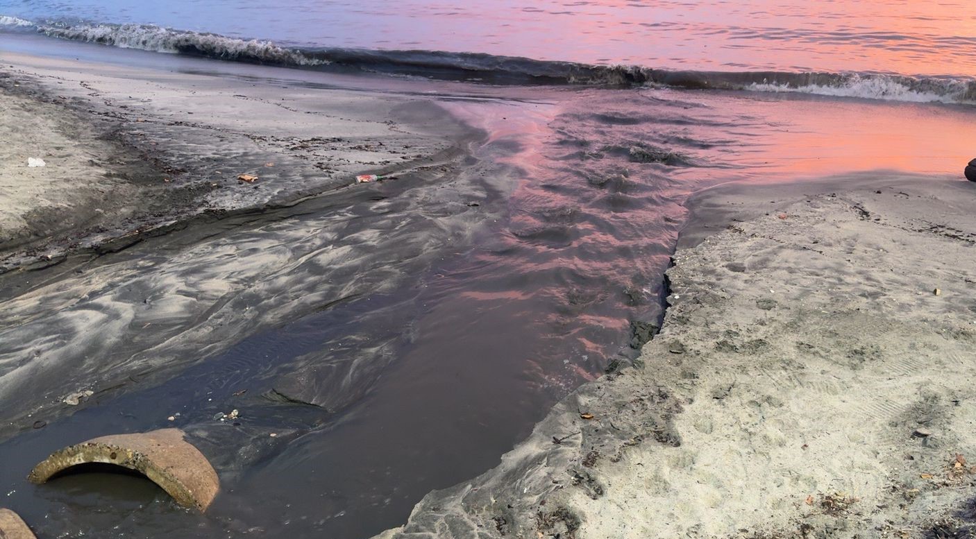 Aguas residuales cayendo al mar en horas de la tarde