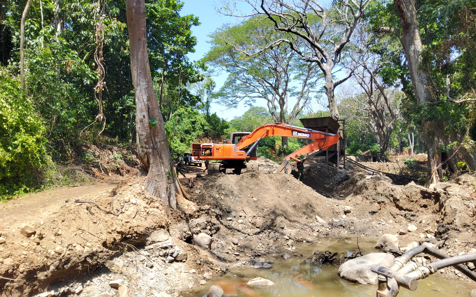 Maquinaria naranja  cerca a cuerpo de agua