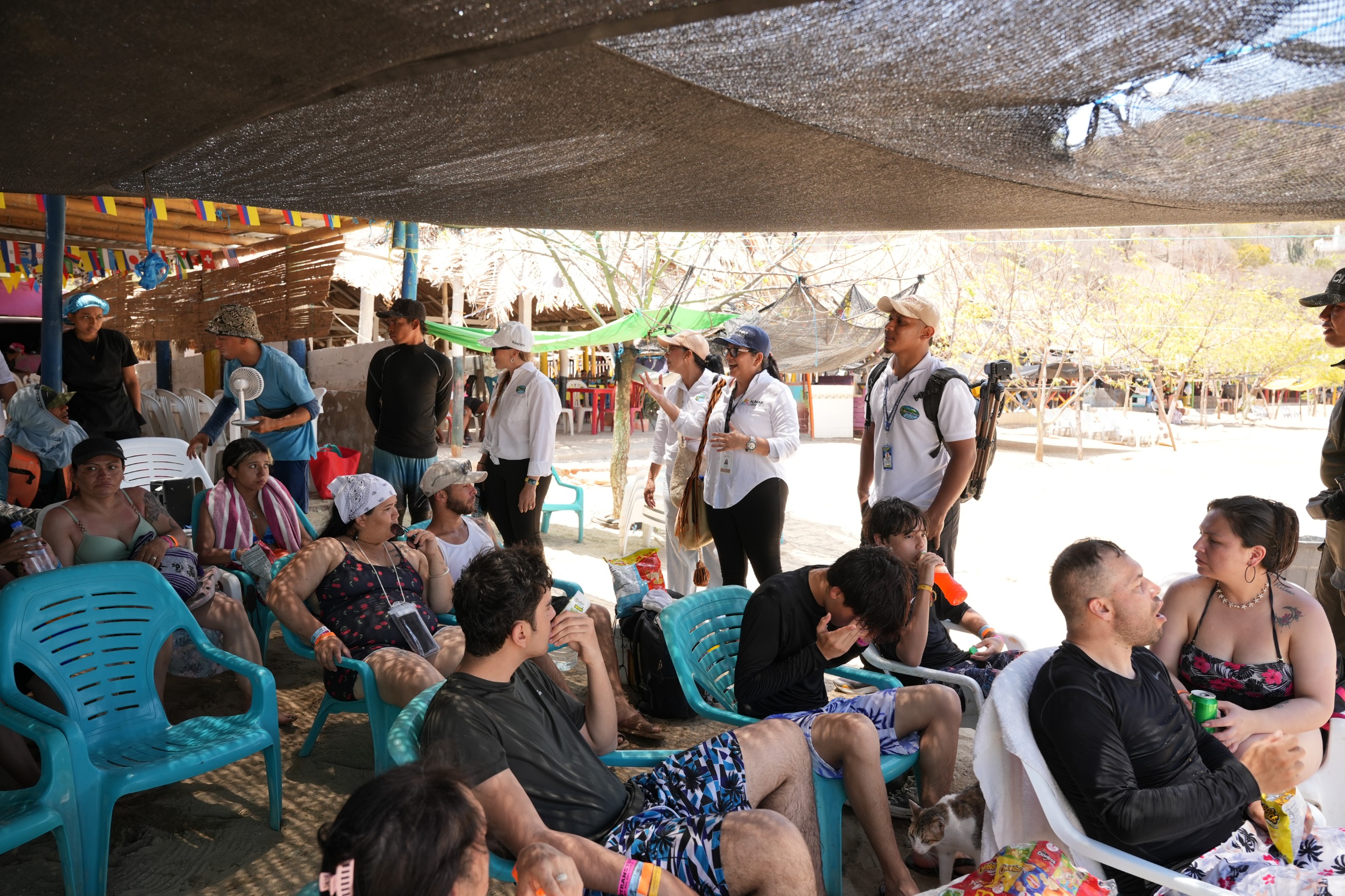 Funcionarios dando charla en la playa