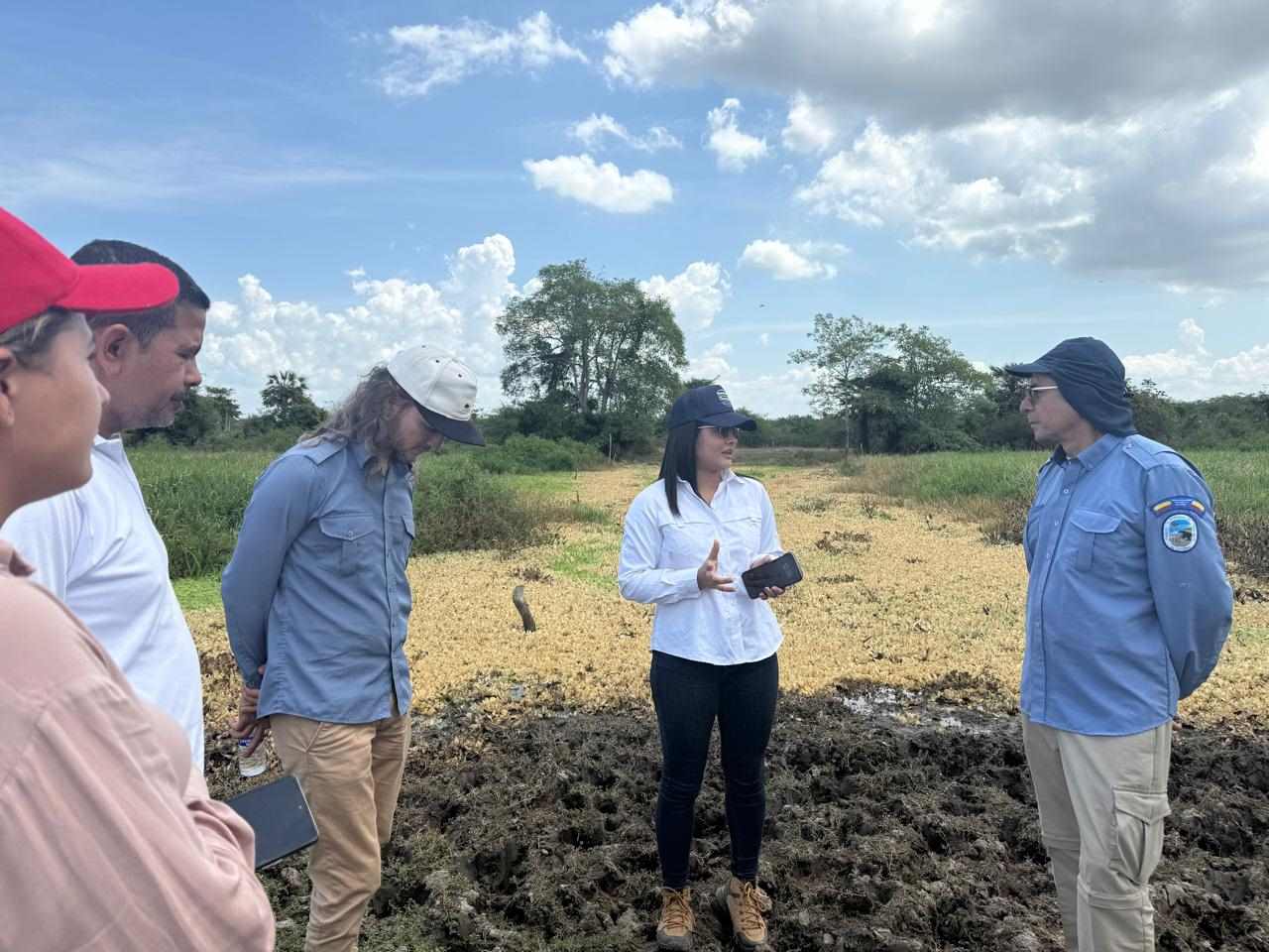 Funcionarios hablando cerca al caño
